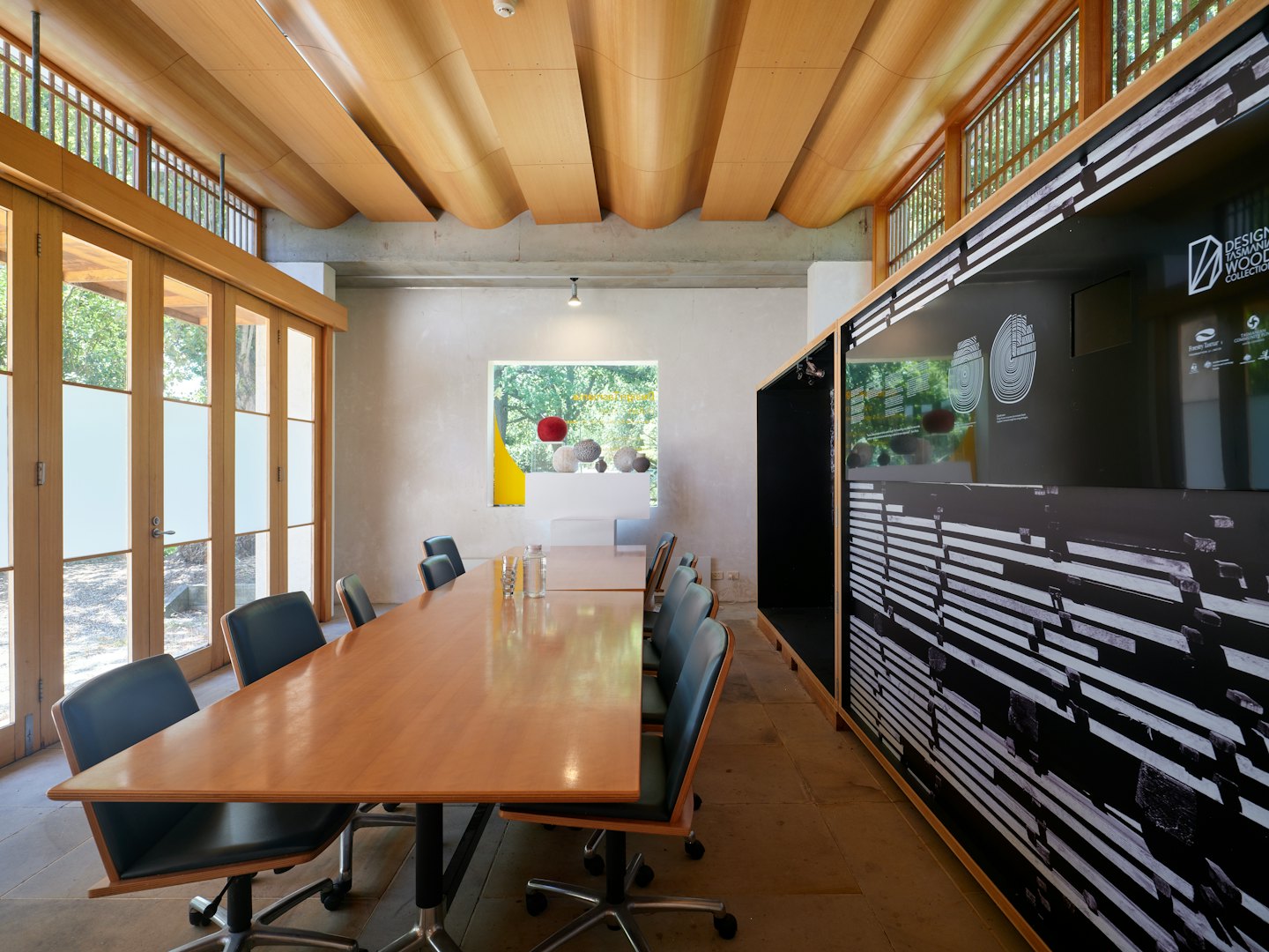 Modern conference room with a long table and glass doors.
